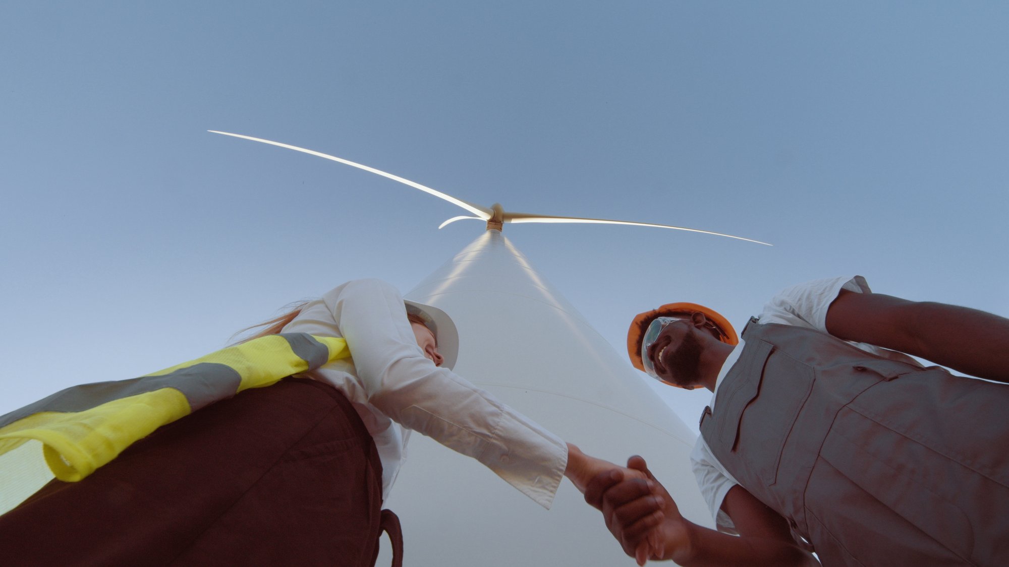 teamwork-of-windmill-engineer-group-worker-working-shaking-hands-on-site-at-wind-turbi-SBI-351191143