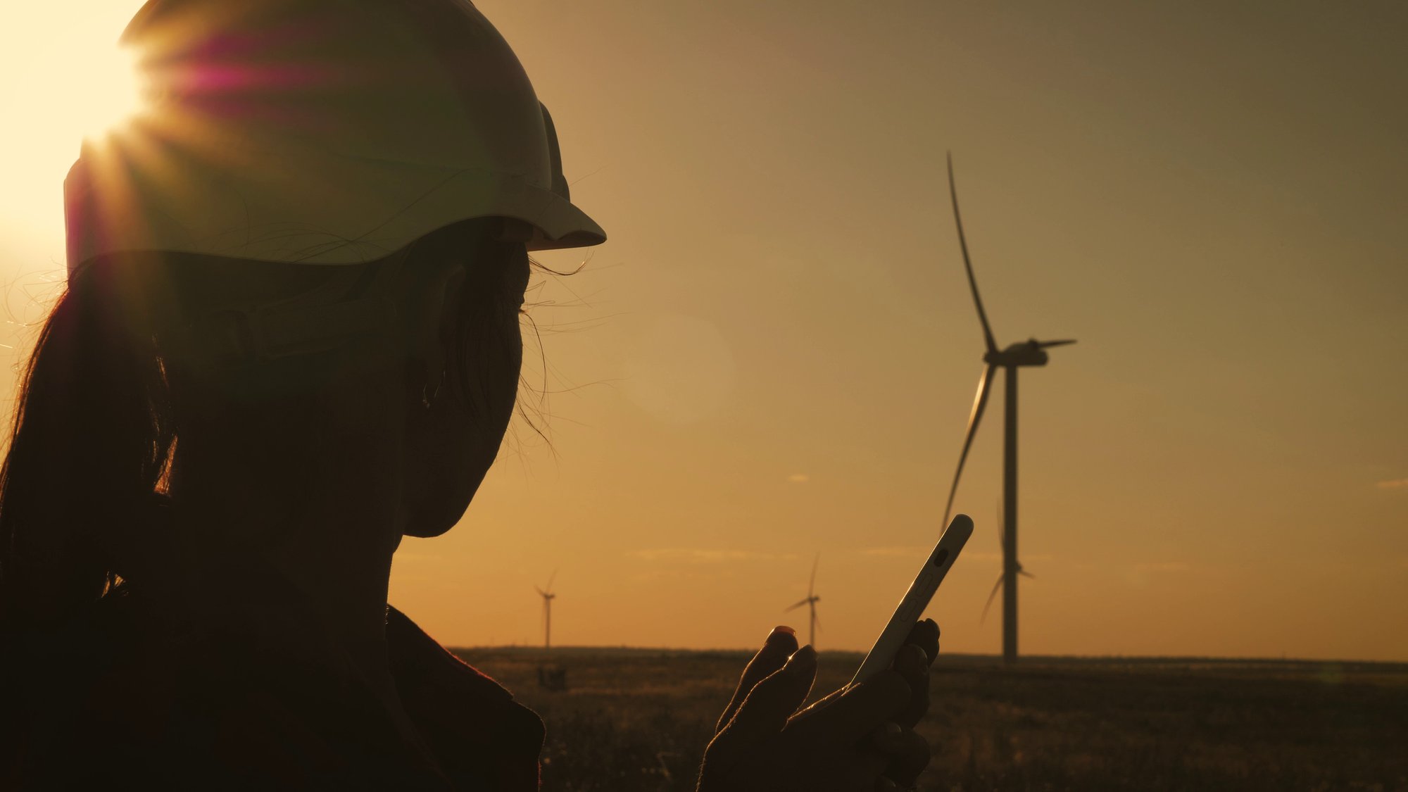 silhouette-female-engineer-working-in-wind-turbine-electricity-industrial-at-sunset-SBI-351612832